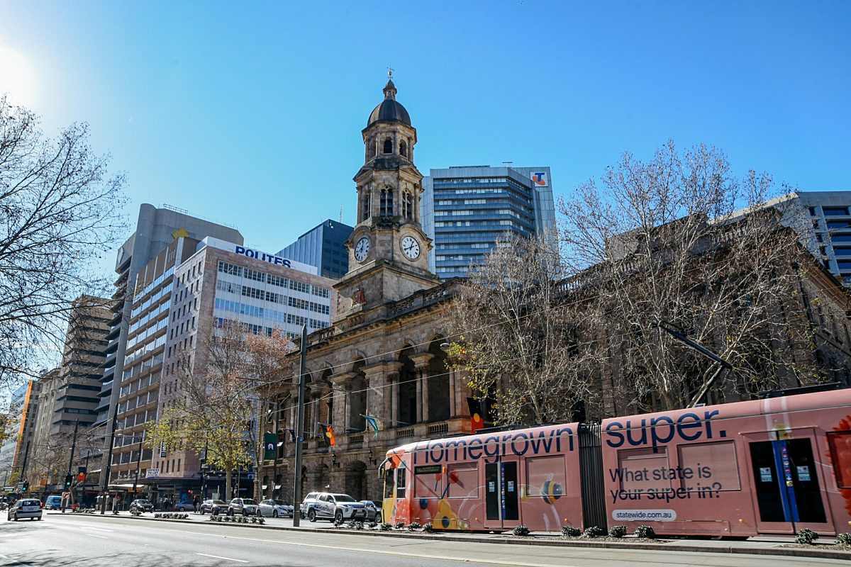 Exterior view of a pink tram passing by the Adelaide Town Hall