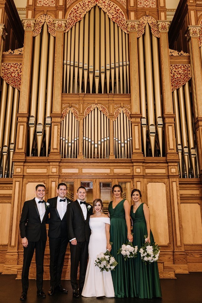 Dominique and Josh with their wedding party in front of the Auditorium organ