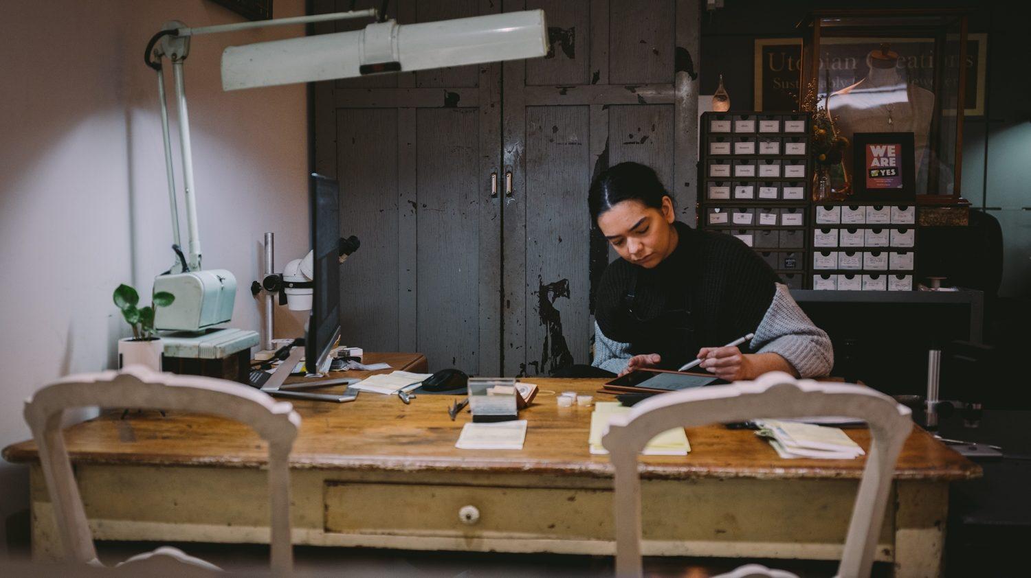 A woman working at a desk with an ipad