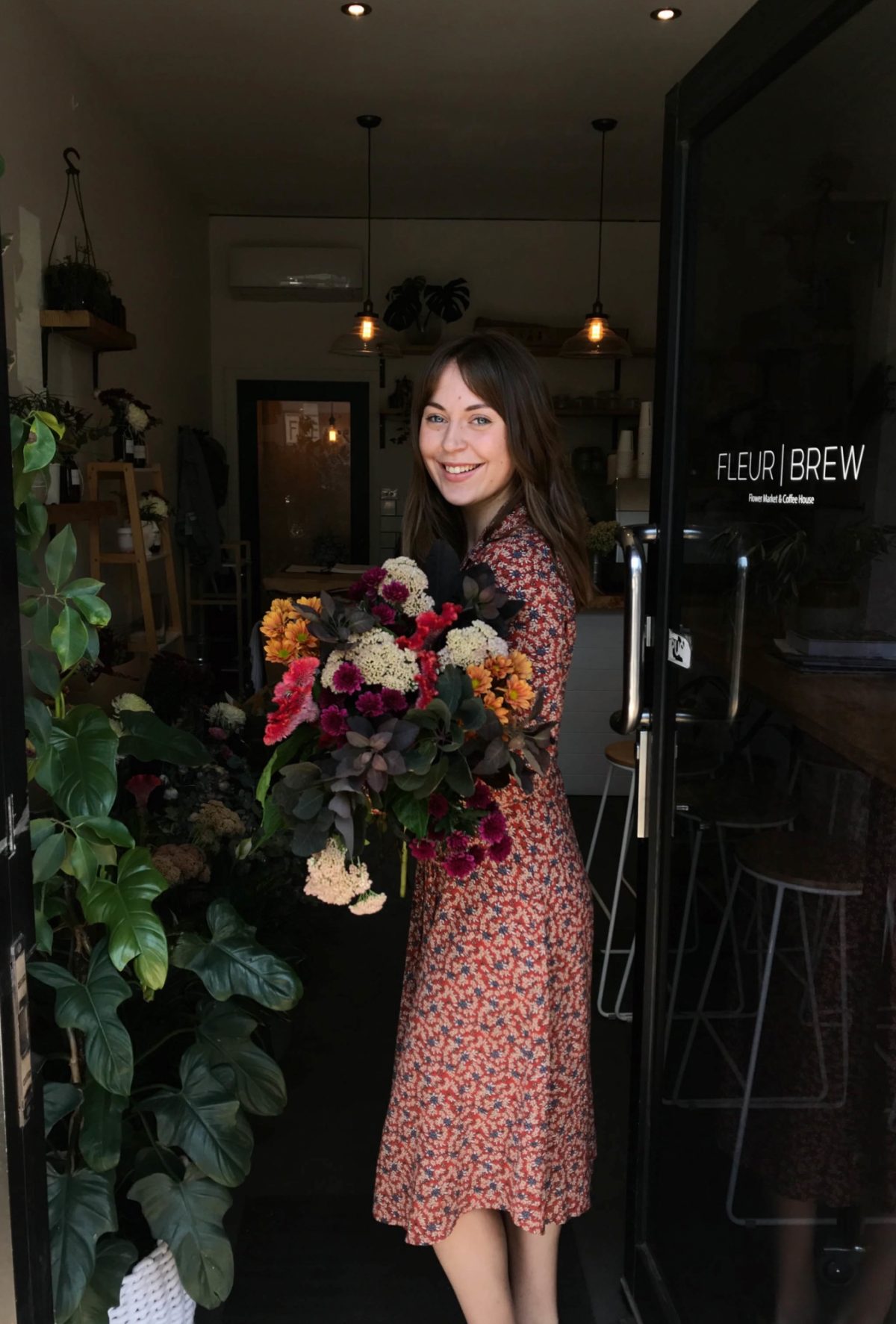 Lady holding flowers, smiling at the camera