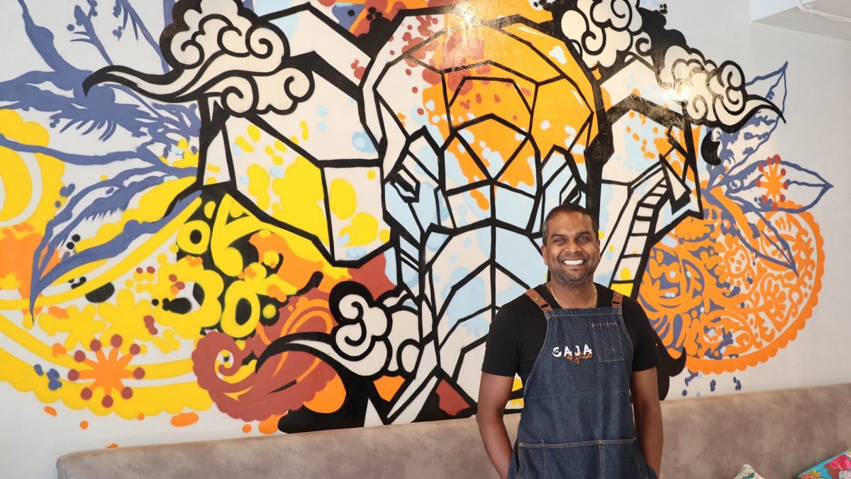 Sashi cheliah in front of mural