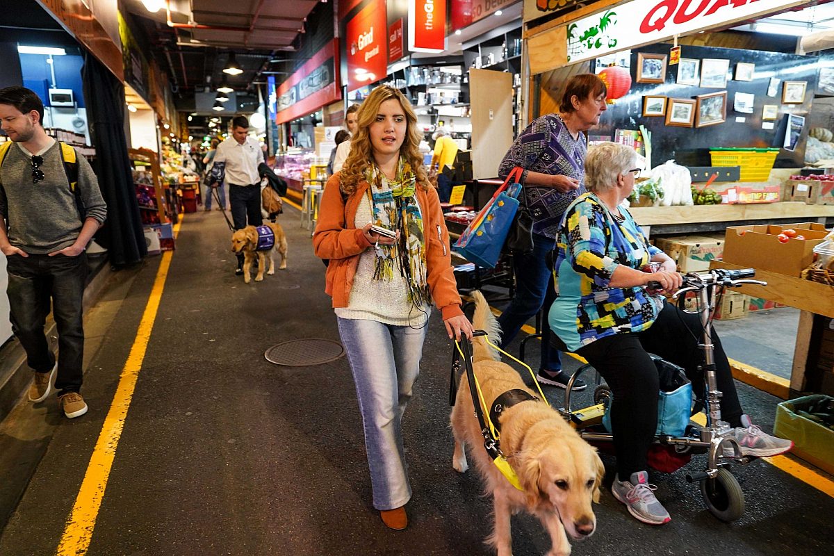 Rachael leahcar with guide dog and bindiapp at central market