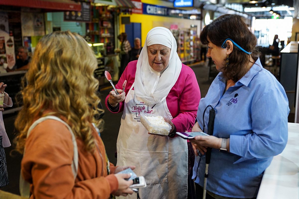 Two women using binidmaps app to find a market stall holder