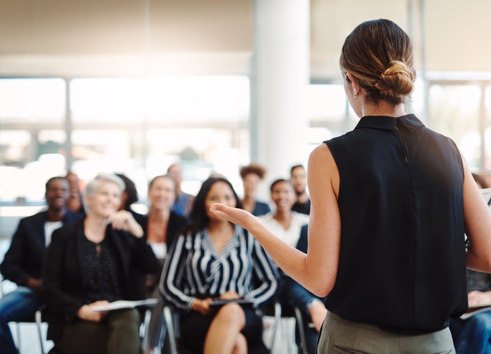 Young businesswoman delivering a speech during a conferenc
